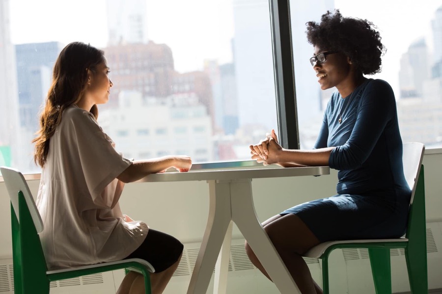 Zwei Frauen im Gespräch am Tisch